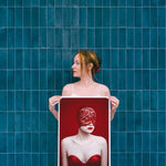 Woman holding a framed artwork against a blue tiled wall