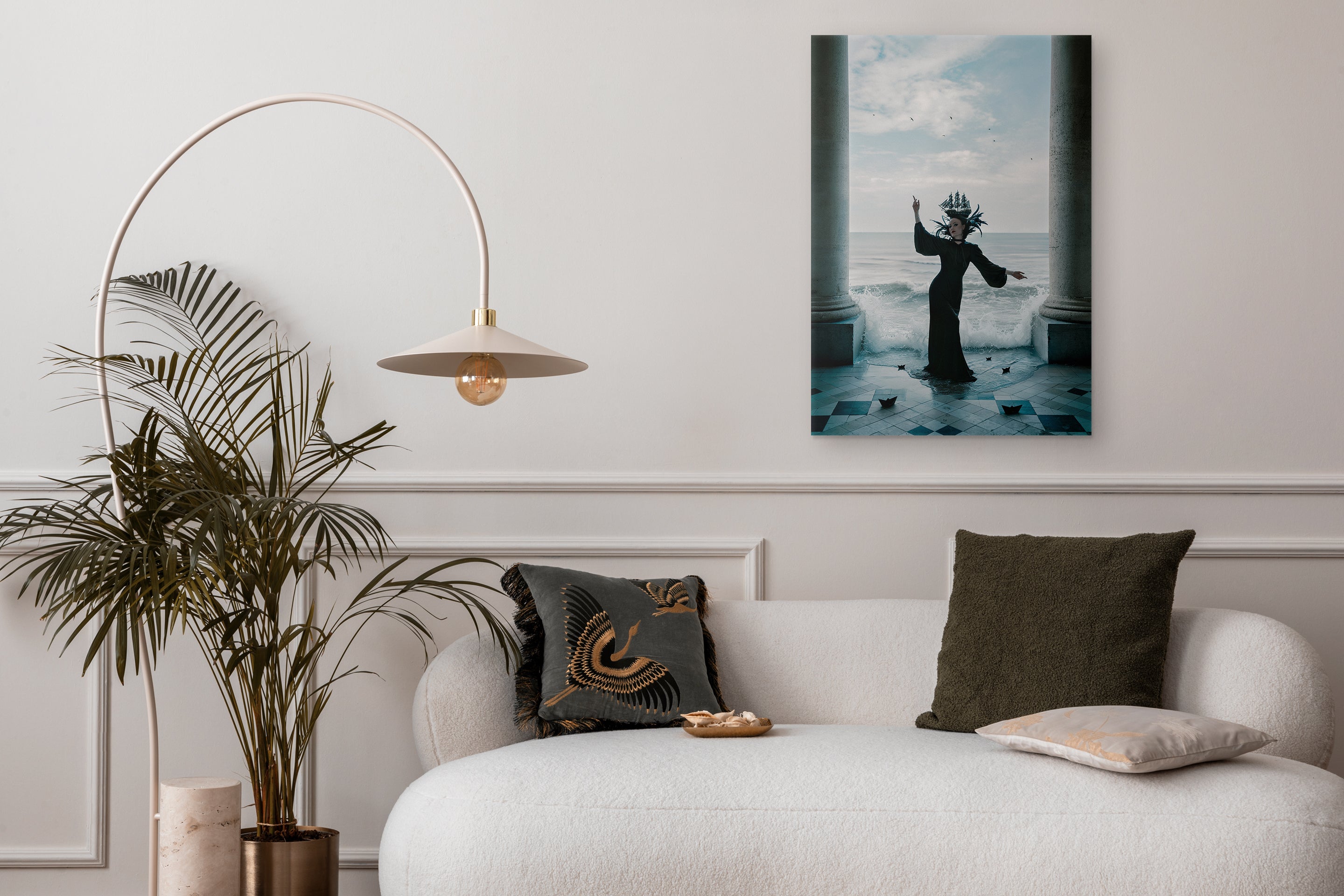 Modern living room with a sofa, decorative pillows, a plant, and a wall art piece.