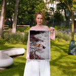 Woman holding a framed artwork in a park