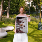 Woman holding a framed artwork in a park