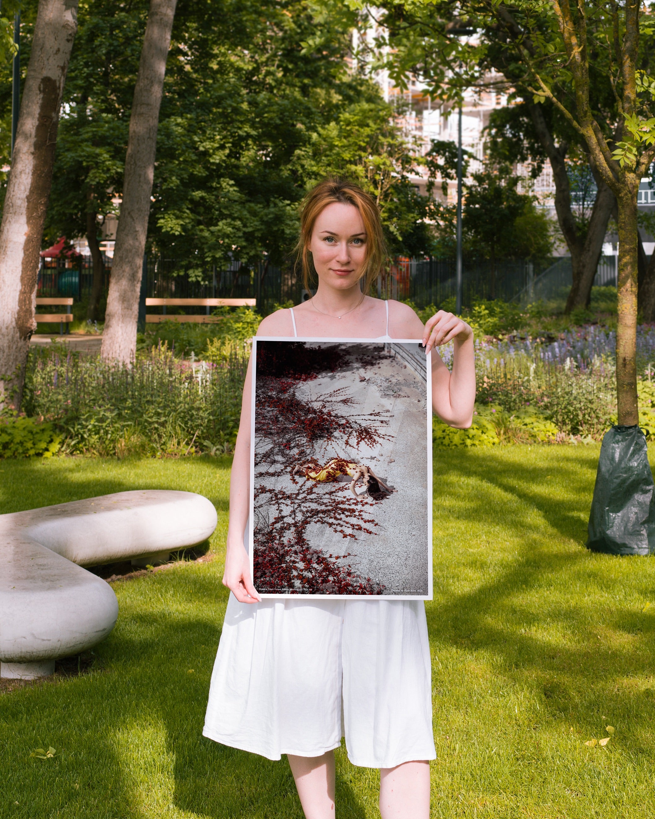 Woman holding a framed artwork in a park