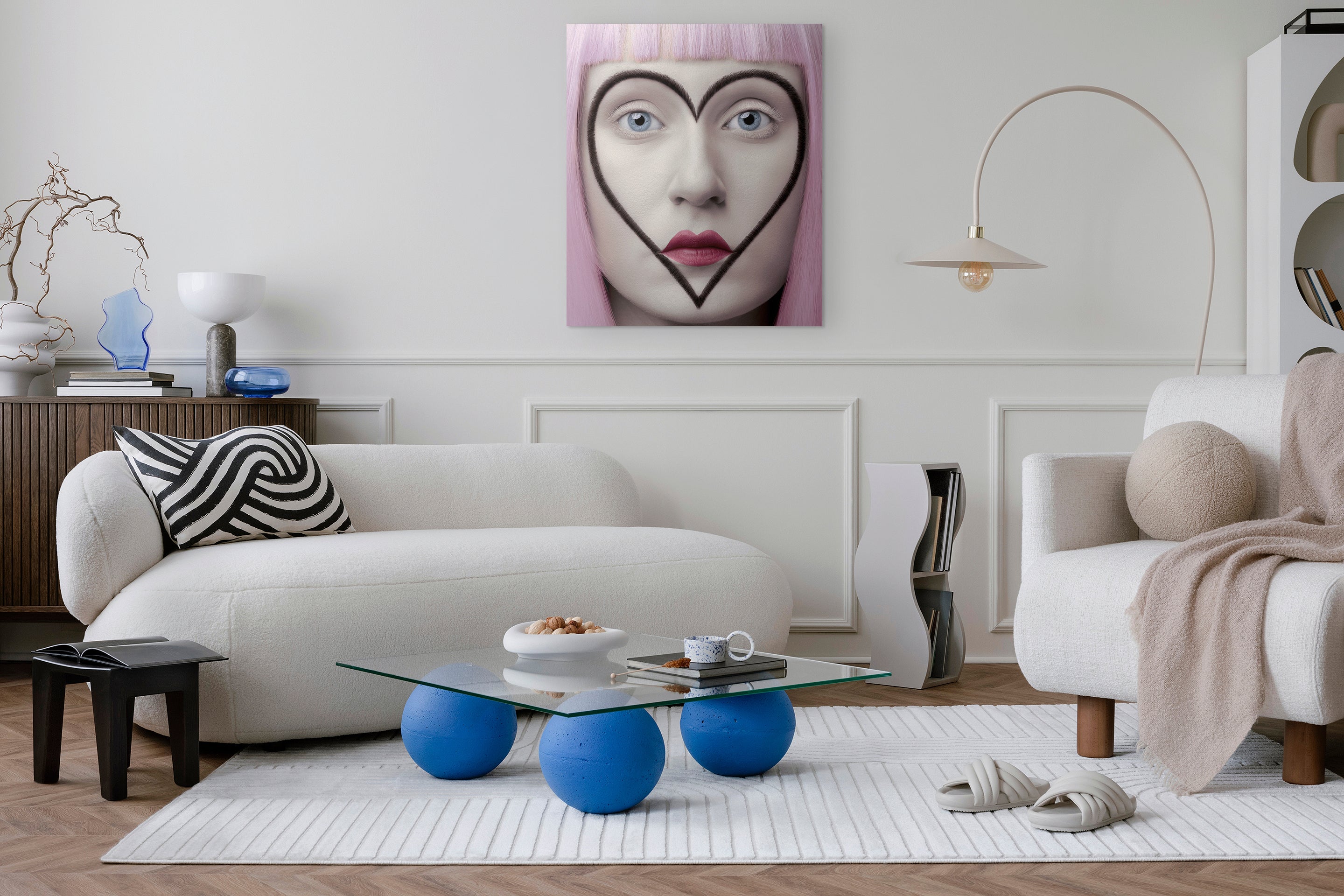 Modern living room with a white sofa, blue coffee table, and decorative wall art.
