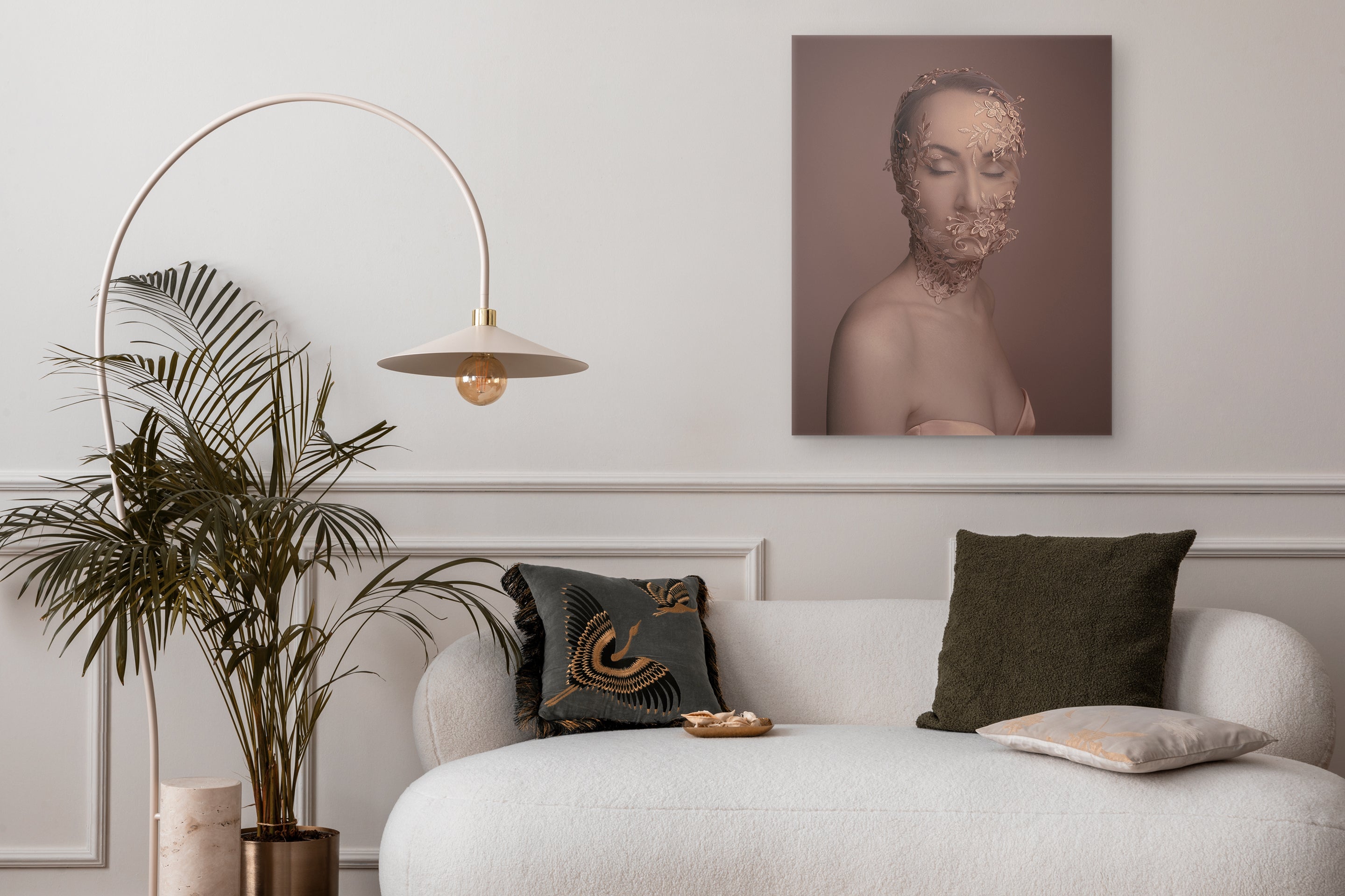 Modern living room with a white sofa, decorative pillows, a plant, and a wall art piece.