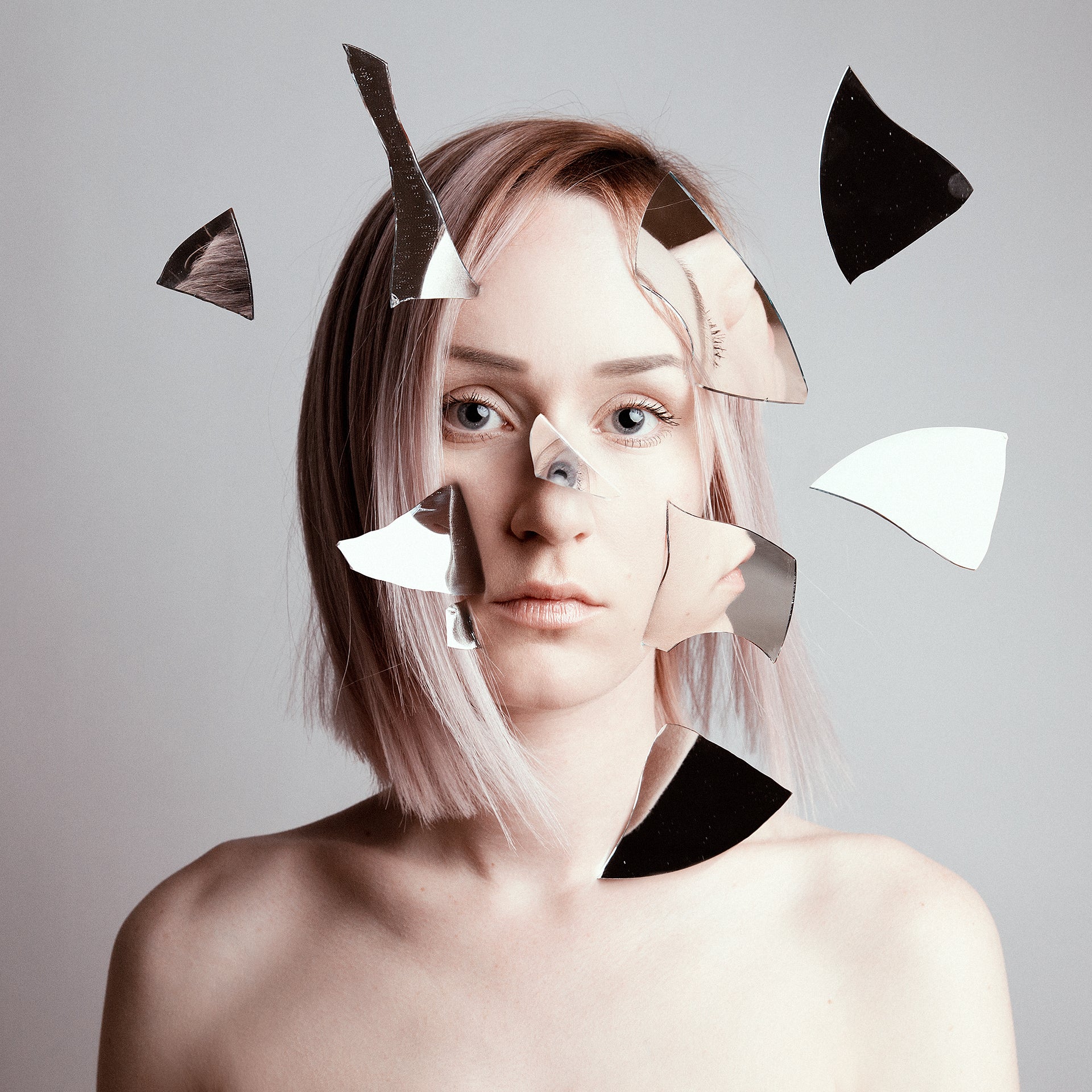 Artistic photo of a person with geometric shapes overlayed on their face against a gray background