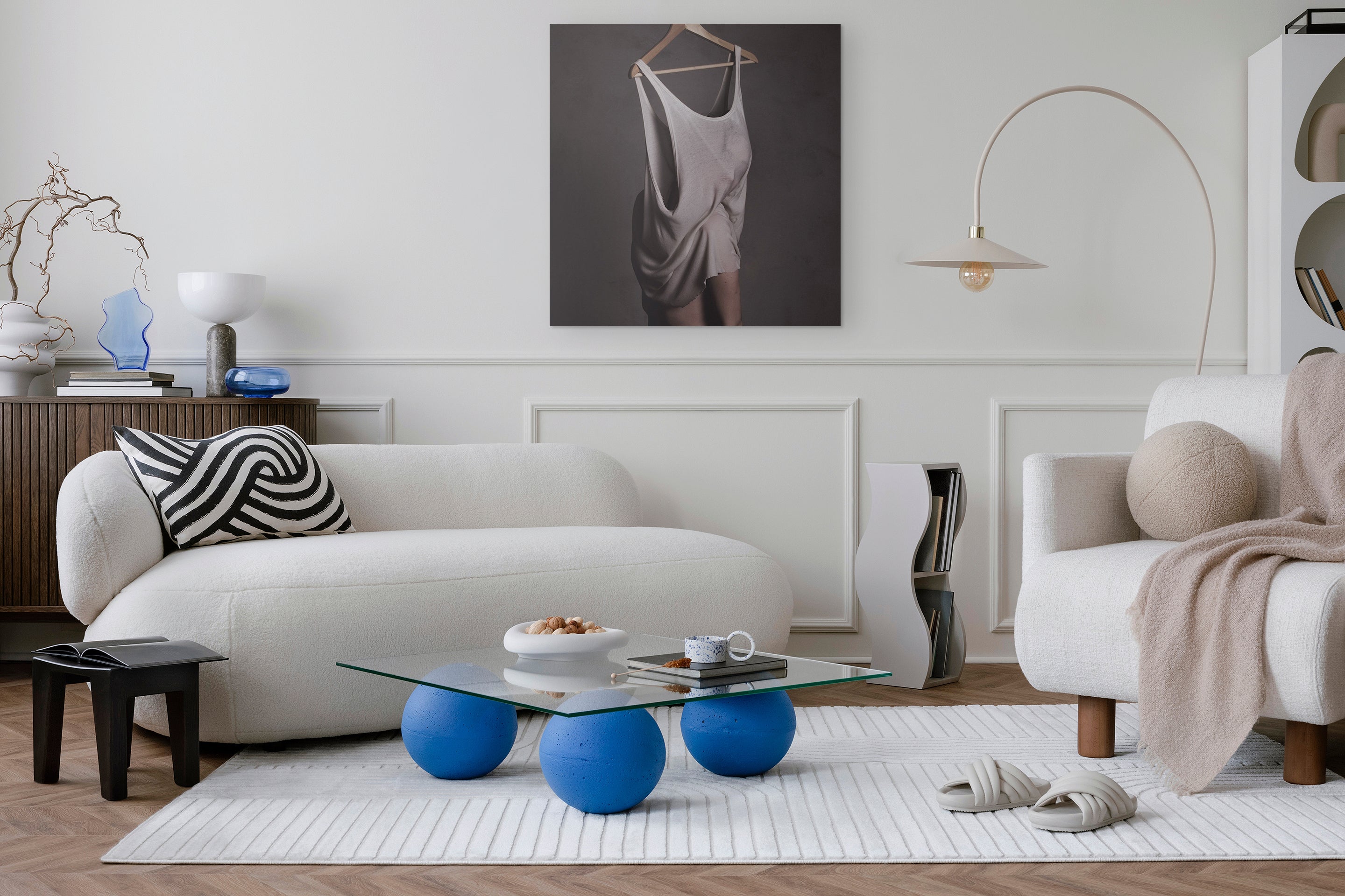 Modern living room with a white sofa, blue coffee table, and decorative items.