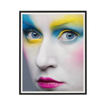 Framed artwork of a face with colorful makeup on a white background